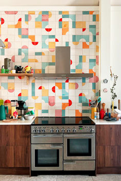 An installation of Smink Studio tiles in a colourful, happy pattern of red, orange, blue and yellow. Tile Feature Wall, Backsplash Installation, Printed Tiles, Converted Church, Patterned Kitchen Tiles, Reclaimed Tile