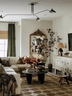 a living room filled with furniture and a large mirror on the wall over a coffee table