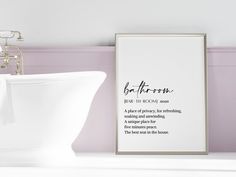 a bathroom with pink walls and a white sink next to a framed print on the wall