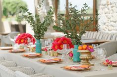 the table is set with flowers and plates