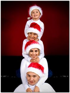 a group of people wearing santa hats on top of each other