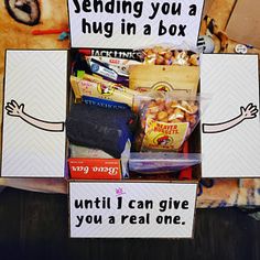 a stuffed animal is sitting in front of a box filled with snacks and other items