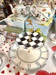 a table topped with lots of plates covered in cartoon character designs and boxes on top of it