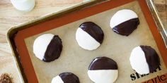 six chocolate covered cookies on a baking sheet