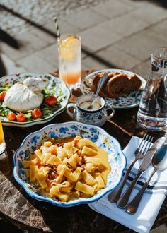 a table topped with plates of food and glasses of orange juice on top of it