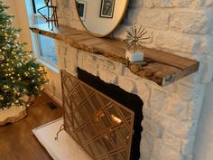 a living room with a fireplace and a mirror on the wall next to a christmas tree