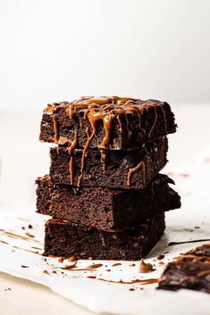 three brownies stacked on top of each other with chocolate drizzled over them