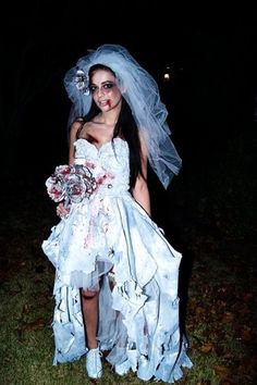 a woman dressed up as a zombie bride in the dark with her veil pulled back