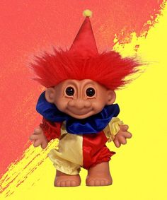 a troll doll with red hair and blue collar