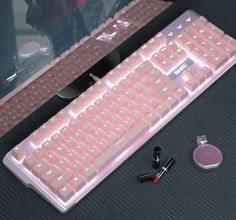 a pink keyboard sitting on top of a desk next to a mouse