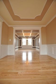 an empty room with hard wood floors and white trim