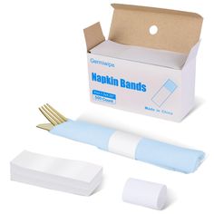 a white box with blue banding next to it and two gold scissors in front of it