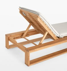 a wooden lounge chair with a white cushion on it's back and seat pad