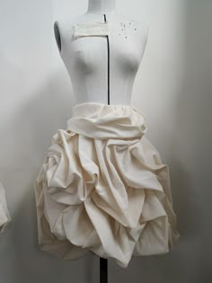 a mannequin wearing a white dress with ruffles on it's skirt