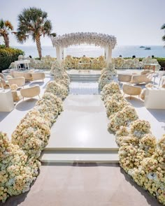 an outdoor wedding setup with white flowers and chairs