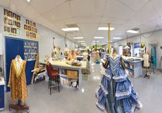 the inside of a clothing store with mannequins and dresses hanging on display