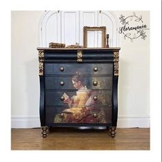 an ornate painted chest of drawers in a room with hardwood floors and white walls, along with a framed painting on the wall