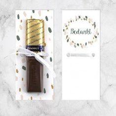 a bottle of chocolate next to a card with a gold foiled bar on it