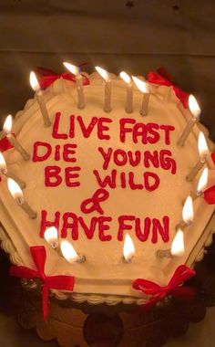 a birthday cake with lit candles on it that says live fast die young be wild and have fun