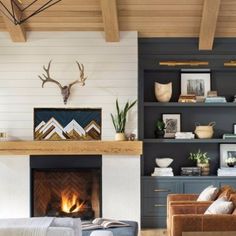 a living room filled with furniture and a fire place next to a wall mounted deer head