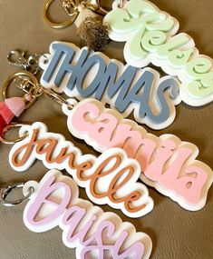 three keychains with the words thomas, charlotte, and danielle written on them