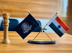 two small flags on a wooden table with the word ias in front of them