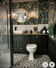 a bathroom with black and white tile flooring and wallpaper, including a toilet