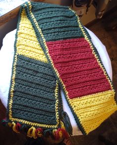 two crocheted scarfs sitting on top of a white plate