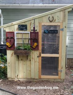 a small wooden shed with flowers in the window