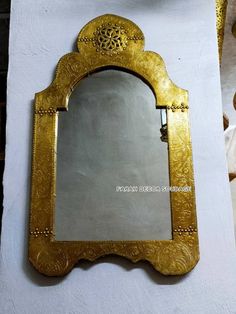 an ornate gold framed mirror sitting on top of a white table next to a teddy bear