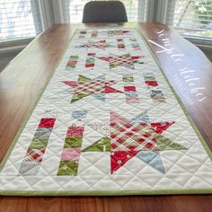 a quilted table runner on top of a wooden table