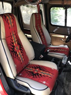 two seats in the back of a truck with native designs on them, one is red and white