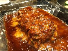 meatballs covered in gravy sitting on top of a metal pan with sauce