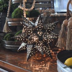 a lighted star decoration sitting on top of a wooden table