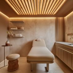 a spa room with a bed, sink and shelves on the wall next to it