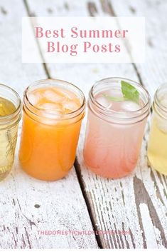 four jars filled with drinks sitting on top of a white wooden table next to each other