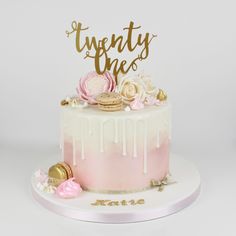 a pink and white cake with gold lettering on top