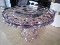 a glass cake plate sitting on top of a wooden table