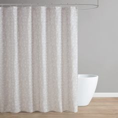 a white shower curtain hanging on the side of a bathtub next to a bowl