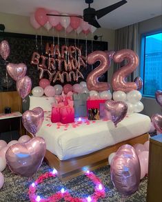 a bed with pink and silver balloons on it that say happy 21st birthday to the two year old