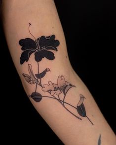 a black and white flower tattoo on the arm