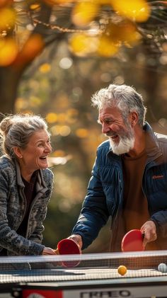 an older couple playing ping pong in the park