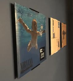 there are three pictures hanging on the wall next to each other, and one has an image of a baby swimming