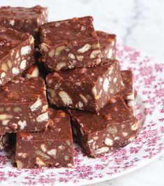 a pile of chocolate brownies sitting on top of a white and blue table cloth