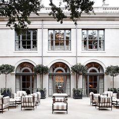 chairs and tables in front of a large building