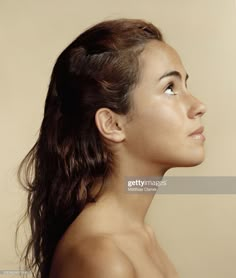 a woman with long hair and no shirt looking up at something in the sky stock photo