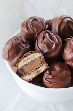 a white bowl filled with chocolate covered donuts