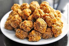 a white plate topped with meatballs on top of a table