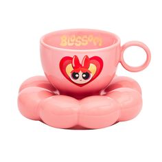 a pink cup sitting on top of a saucer with the word blossom written in it