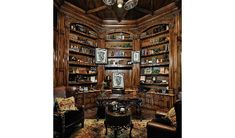 a living room filled with lots of furniture and bookshelves on top of wooden shelves